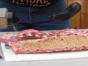 Applying seasoning to the back side of the ribs