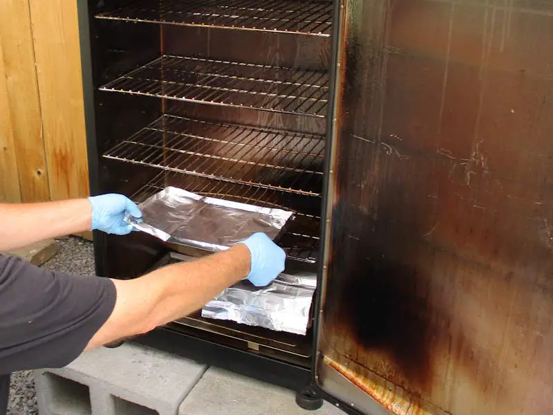 Inserting a homemade foil tray to catch the grease drippings